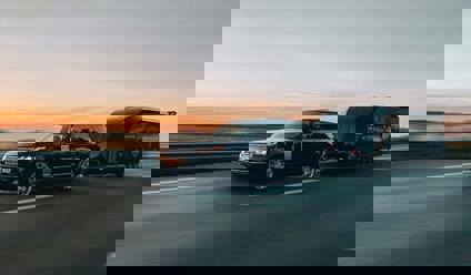 A car towing a trailer on a road.