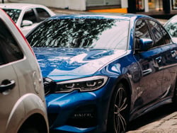sleek blue saloon car parked on a city street