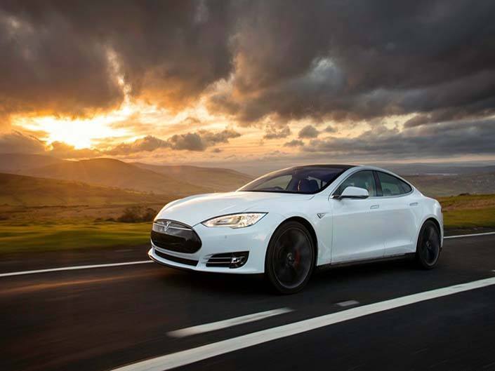 white tesla model s driving on road