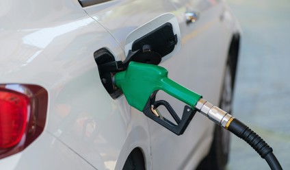 a white car with a green gas pump