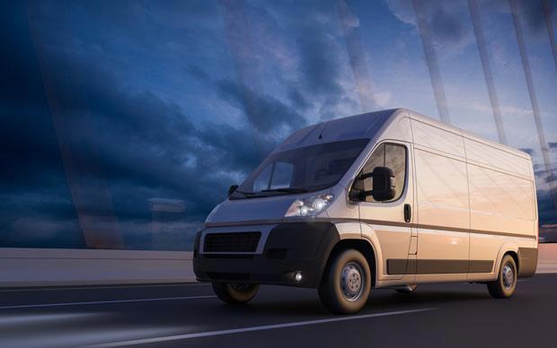 A commercial van driving over a suspension bridge.