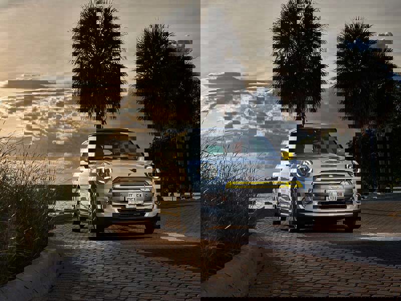 Mini Electric Hatchback in a tropical area at sunset