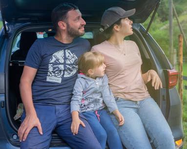 Family sitting on the back of a car