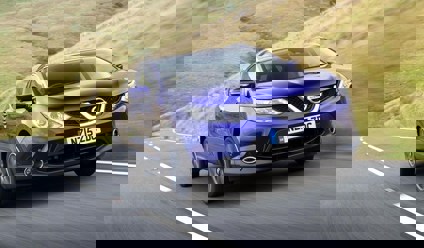 blue nissan qashqai driving on country road