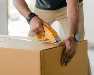 man taping carrying box with scotch tape