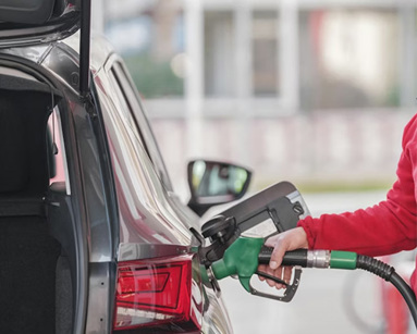 a woman pumping petrol into her car at the petrol station