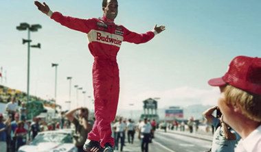 A promotional image for the documentary "Uppity: The Willy T. Ribbs Story," featuring Willy T. Ribbs in a racing suit and helmet.