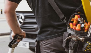 man in black crew neck shirt holding black and yellow power tool