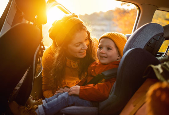 woman smiling at child in car seat