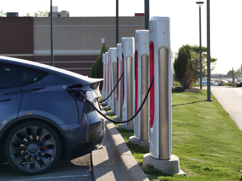 Electric car plugged into a row of charging stations, showcasing modern EV infrastructure