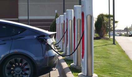Electric car plugged into a row of charging stations, showcasing modern EV infrastructure