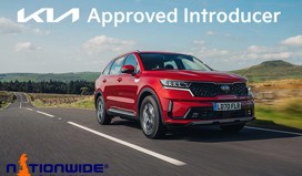 A Kia Sportage driving on the road with a badge for Kia Approved Introducer.