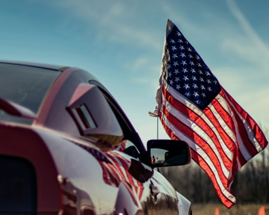 a-red-car-with-an-american-flag-on-top-of-it