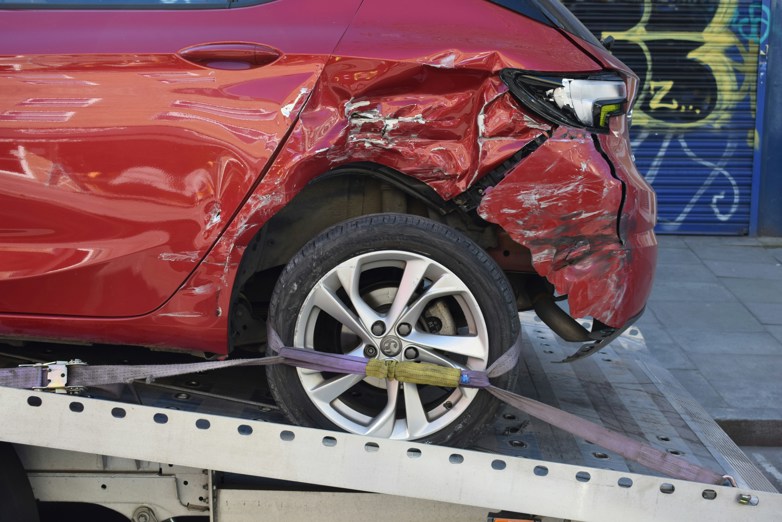 a red car on a flatbed tow truck