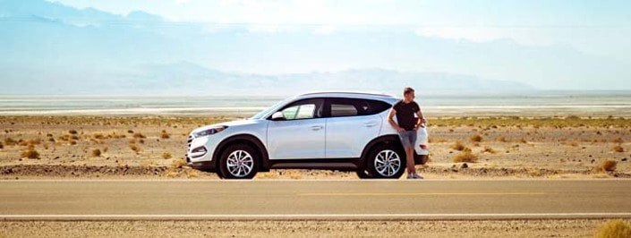 white SUV and man in the desert