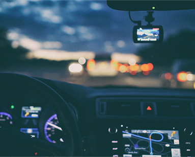 A sunset from the view point of behind a car steering wheel. 