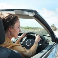 Woman in Brown Jacket Driving Car