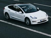 Tesla Model 3 driving on a highway in Osnabrück, Germany, showcasing modern electric vehicle design
