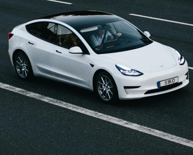 Tesla Model 3 driving on a highway in Osnabrück, Germany, showcasing modern electric vehicle design