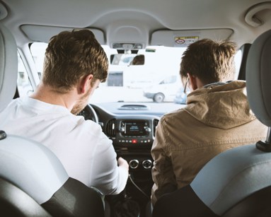 two men sitting in the front of a car