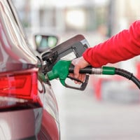 Closeup of man pumping gasoline fuel in car at gas station