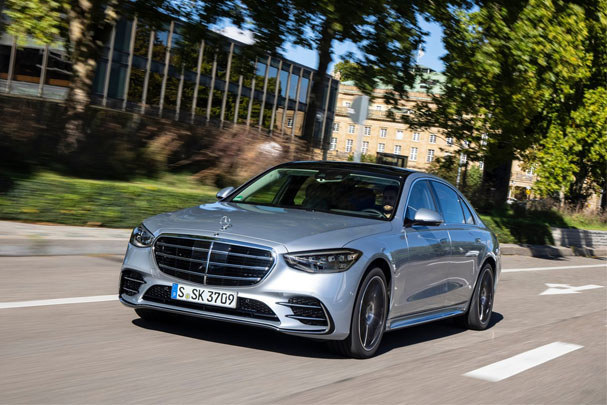 silver mercedes s-class driving on the road 