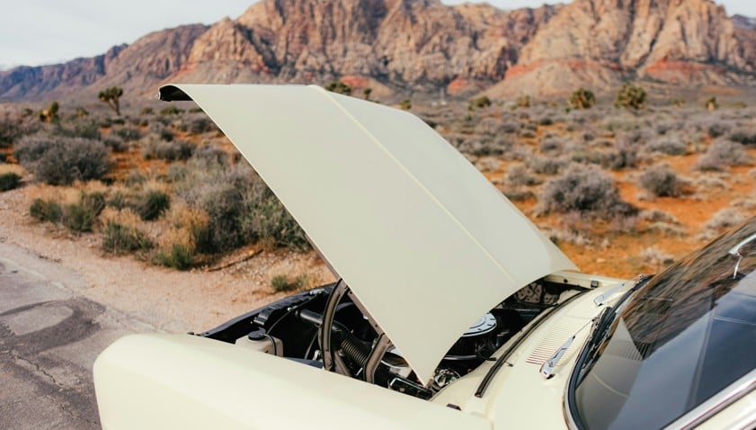 car with hood open in desert landscape