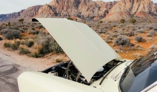 car with hood open in desert landscape