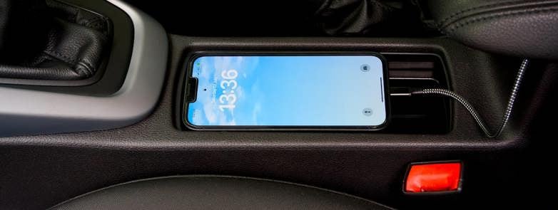 A smartphone charging in a modern car
