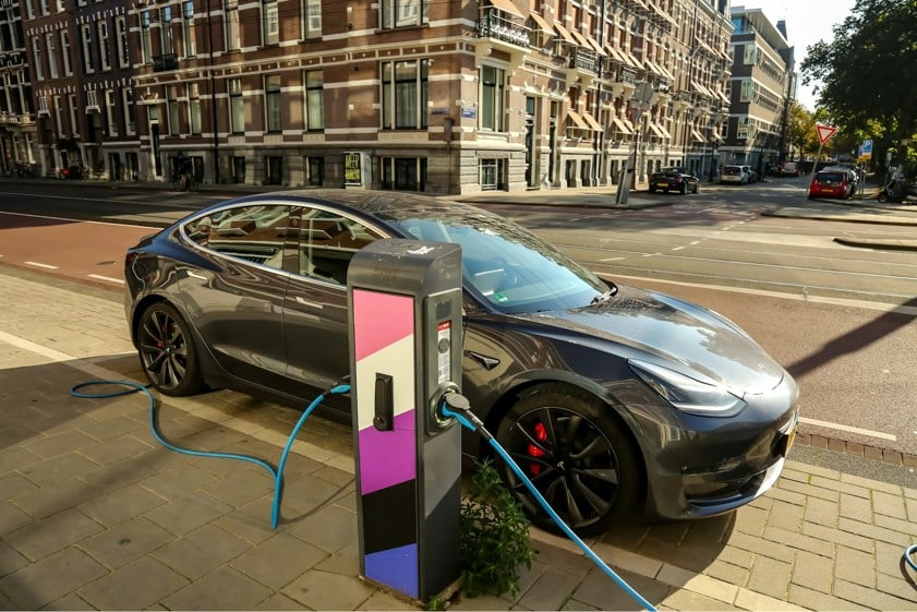 Tesla charging using public charger on the side of a road