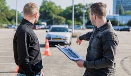 man in black jacket holding clipboard