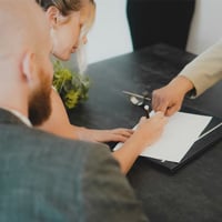 a woman and man signing a document