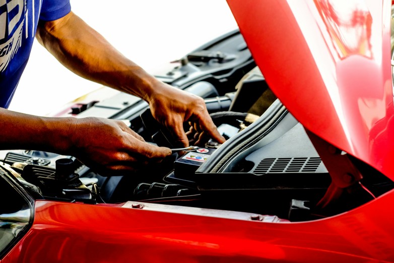Person fixing car during daytime