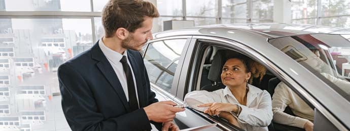 man and woman walking through a car window
