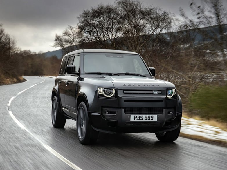 black land rover defender driving on the road