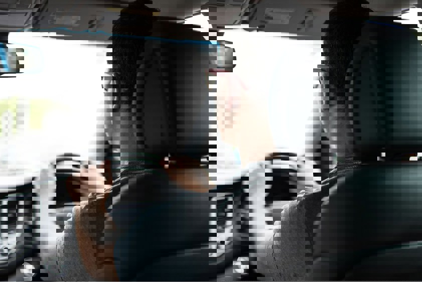Man driving car with both hands on the steering wheel