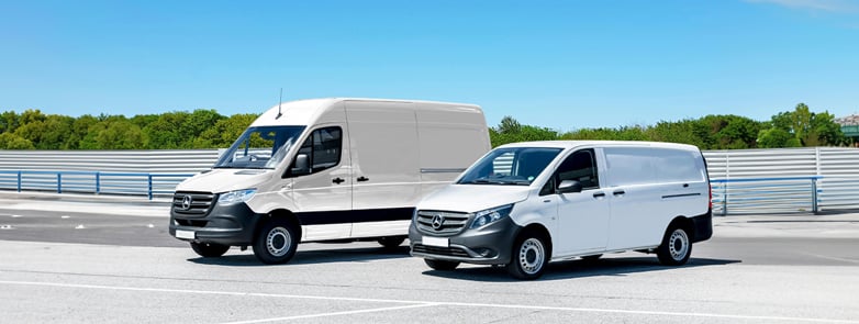 Two white vans parked statuary stationary 1