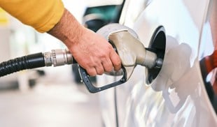 Person filling a white car with fuel