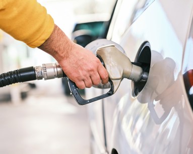 Person filling a white car with fuel