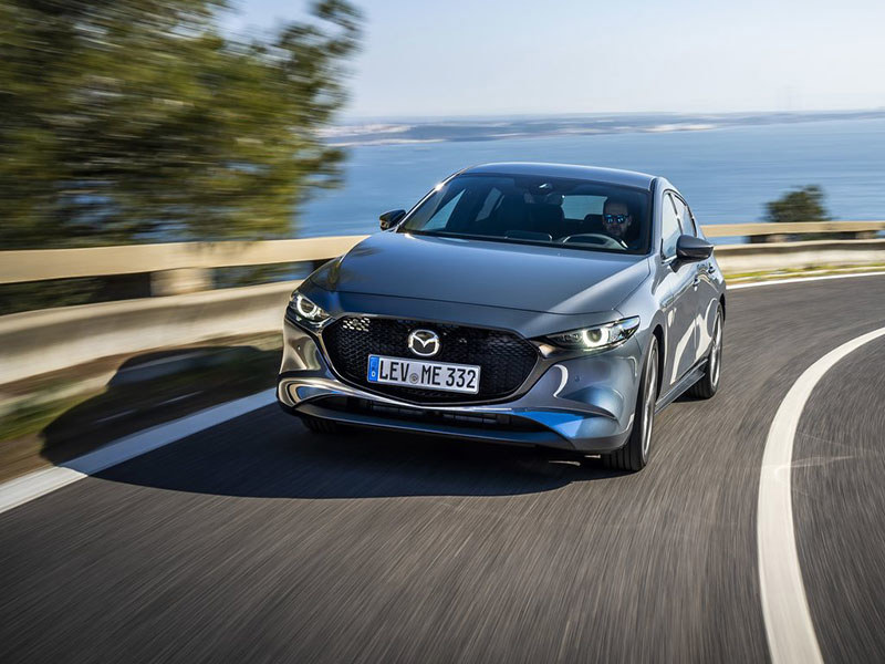 grey mazda 3 driving on open road