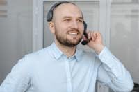 Smiling call center agent wearing a headset providing customer service in an office environment