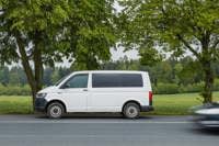 A white van parked beside a scenic road