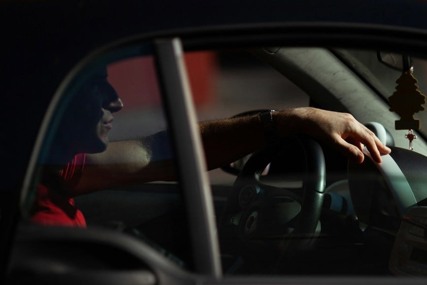 Person sitting in vehicle at night