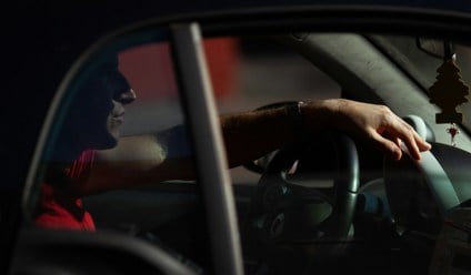 Person sitting in vehicle at night