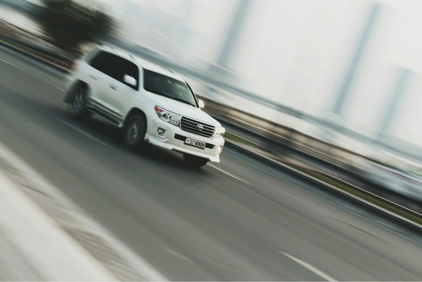 White SUV driving on a highway