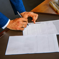 person writing on white form paper