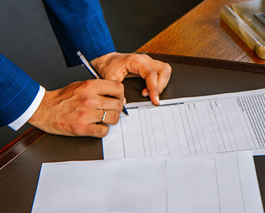 person writing on white form paper