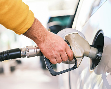 a man pumping gas into his car at a gas station