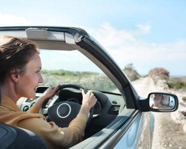 Woman driving convertible car