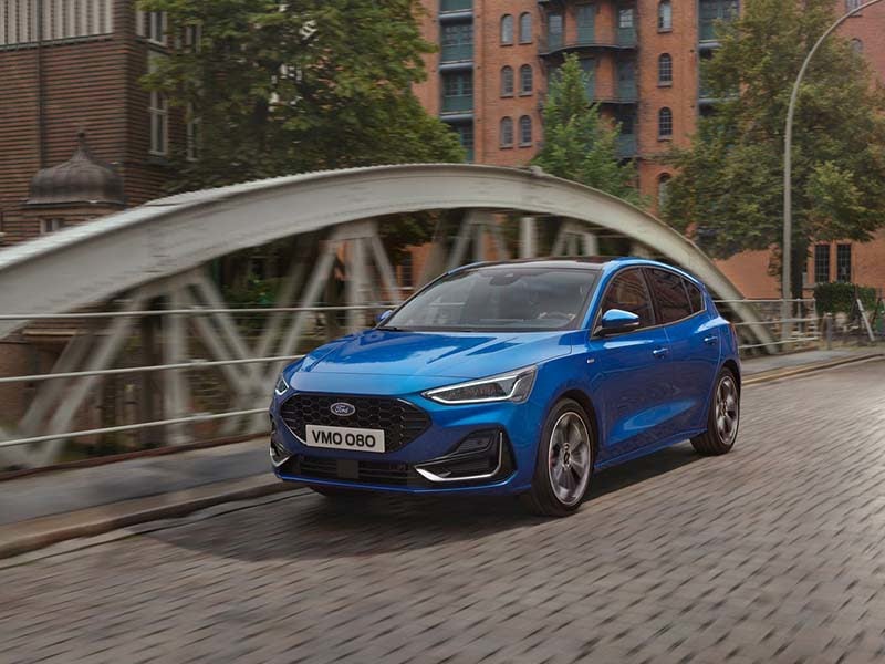 Blue Ford Focus crossing a city bridge